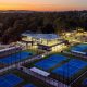 A night view of the tennis courts at Glen Waverly Sports Hub with the primary building lit up